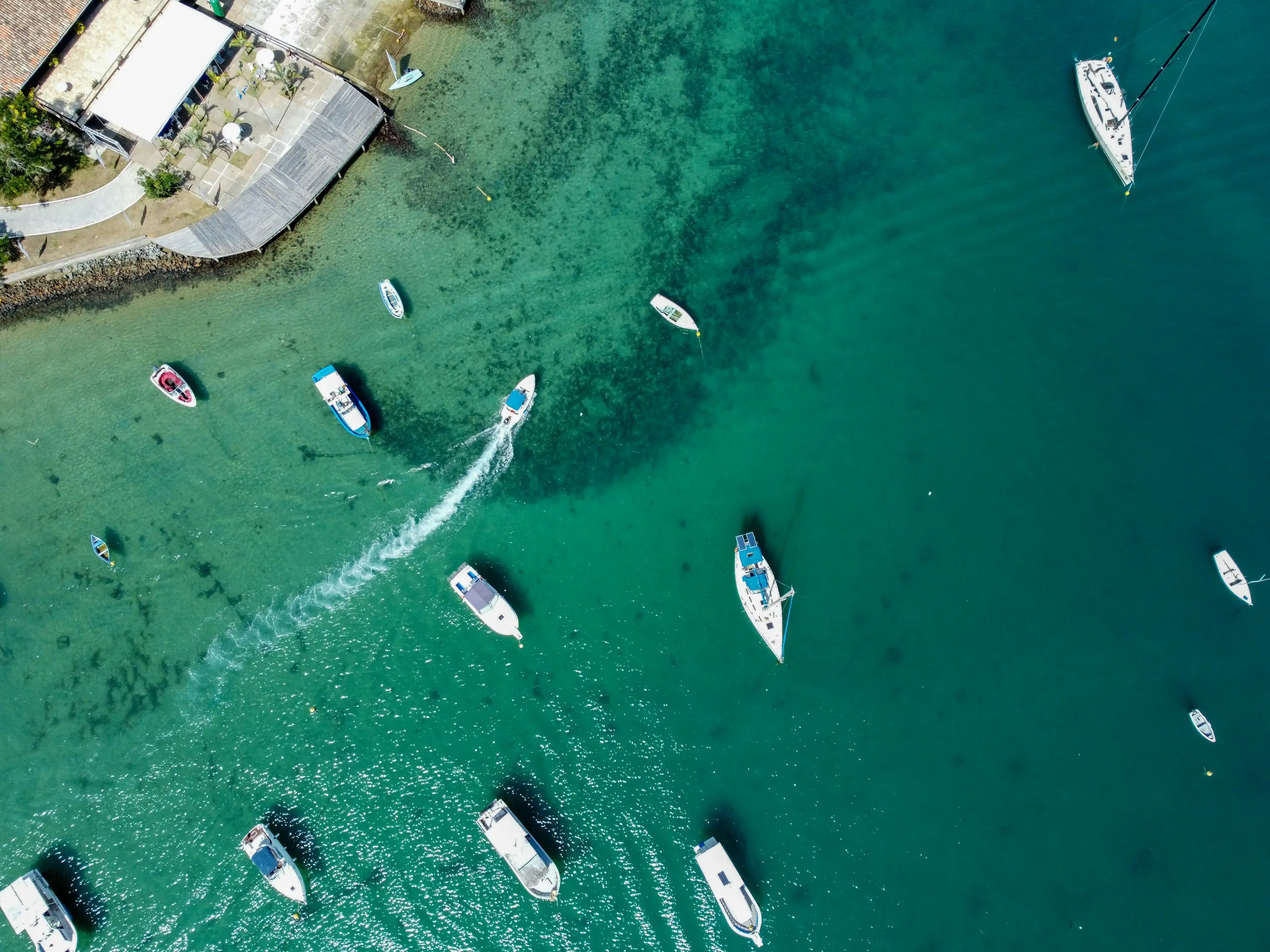 Boats anchored in bright turquoise water beside a marina dock (placeholder image for the Savannah marina near Wilmington Island and Thunderbolt)